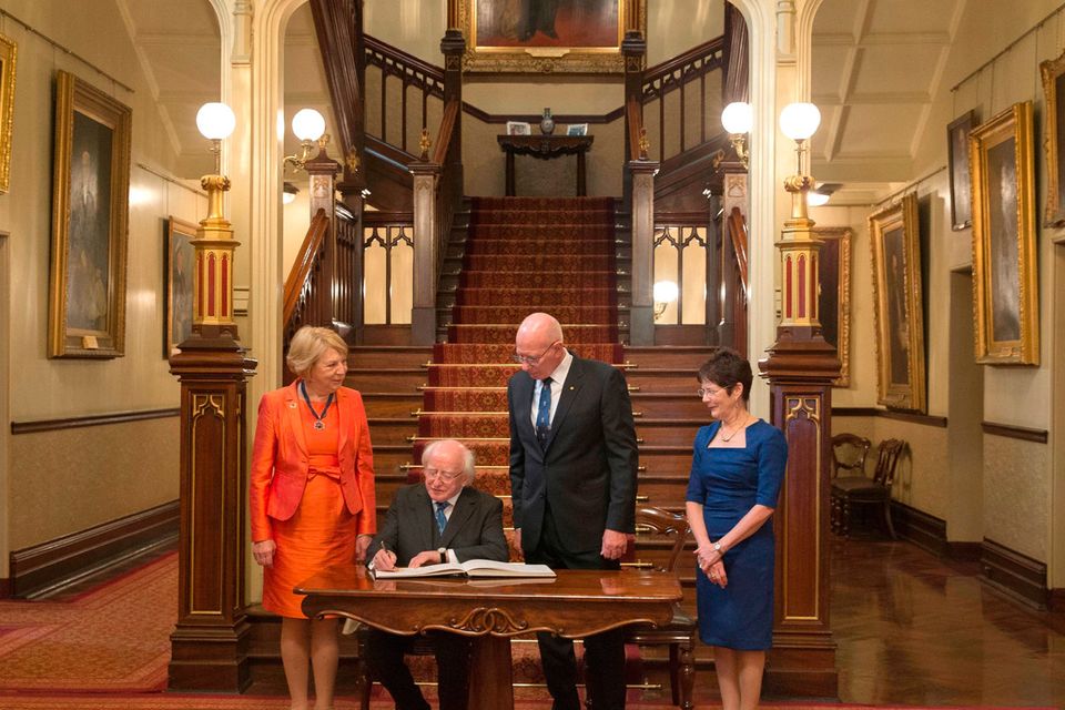 Ireland's President Michael Higgins, second left, and his wife Sabina, left, sign a visitor's book with New South Wales state Governor David Hurley, second right, and his wife Linda, right, looking on at Government House in Sydney, Australia, Tuesday, Oct. 17, 2017. (AP Photo/Steve Christo, Pool)