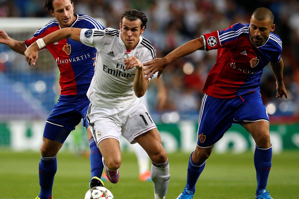 Real Madrid's Gareth Bale (C) fights for the ball against FC Basel's Luca Zuffi (L) and Walter Samuel