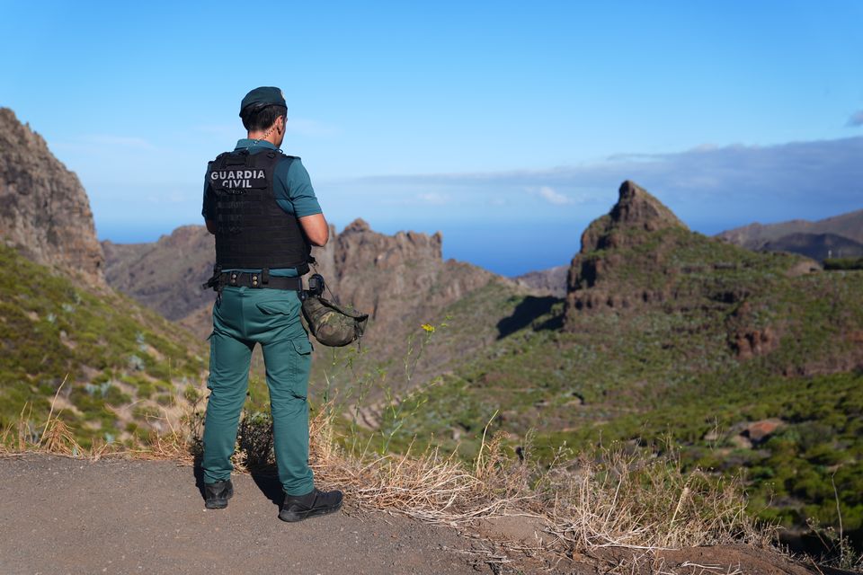 Un oficial de policía observa el terreno cerca de Masca en Tenerife (James Manning/PA)
