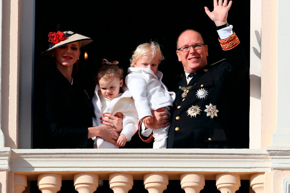 Prince Albert II of Monaco (R) holding Prince Jacques, and princess Charlene of Monaco (L) holding Princess Gabriella, appear on the balcony of the Monaco Palace during the celebrations marking Monaco's National Day
