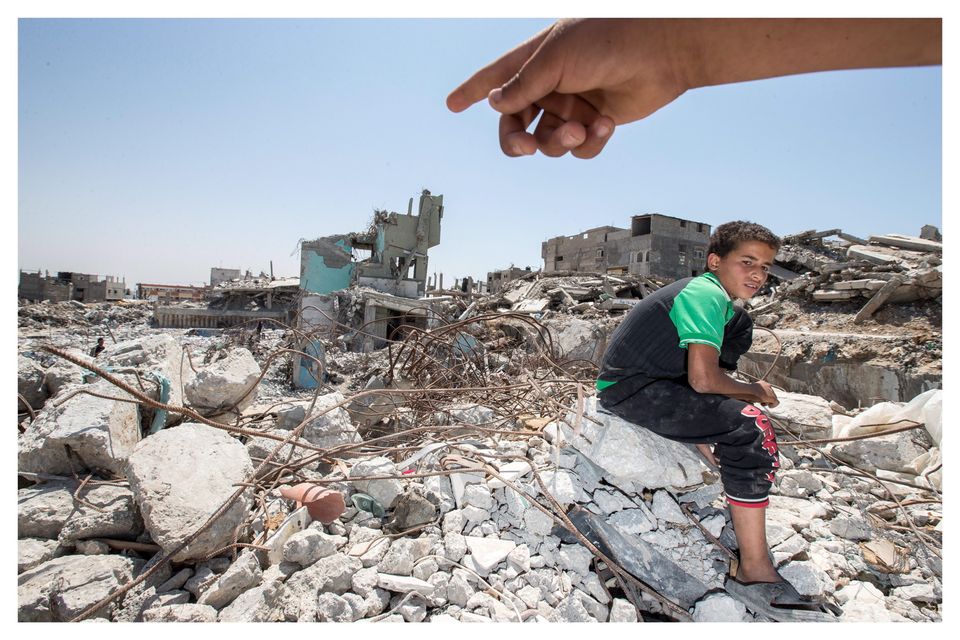 Boy searching for metal at the site of a bombed out hospital in Gaza City. Photo: Mark Condren