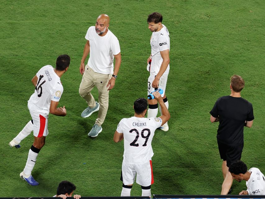 Manchester City manager Pep Guardiola checks on Rodri before the start of extra-time.
