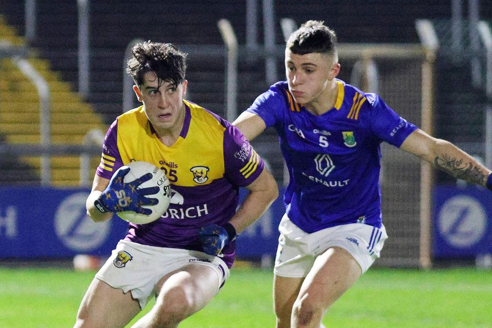 Wexford's Cian Hughes is challenged by Wicklow's Karl Furlong.