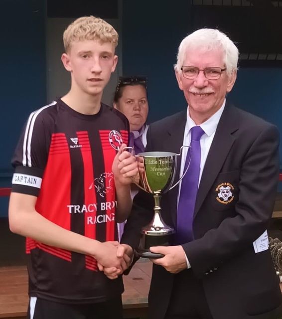 Stephen Murphy of Gorey Rangers receiving the Eddie Tennant Memorial Cup from Ian Lawlor (Chairman).