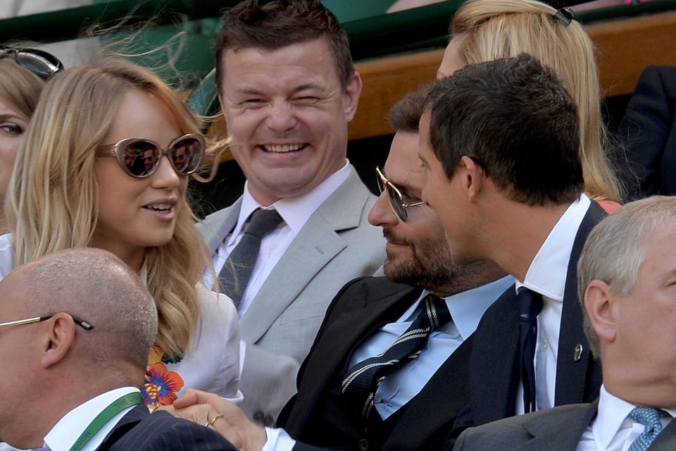Rugby player Brian O'Driscoll (C), model Suki Waterhouse (L), actor Bradley Cooper (CENTRE 2nd R) and television presenter Bear Grylls (CENTRE R) sit on Centre Court at the Wimbledon Tennis Championships
