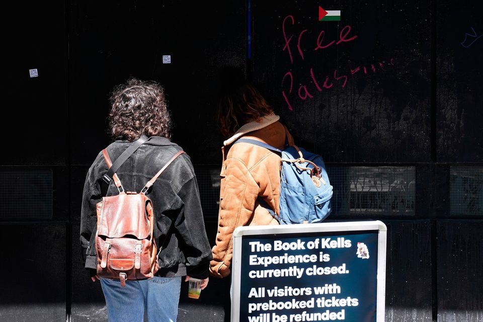 Pro-Palestine slogans on a gate at an entrance to Trinity College, Dublin yesterday. The campus remains closed to the public due to an ongoing pro-Palestinian encampment on its grounds. Photo: Brian Lawless/PA