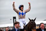 thumbnail: Jockey Rachael Blackmore celebrates aboard Captain Guinness after winning the Champion Chase on day two of the Cheltenham Racing Festival at Prestbury Park