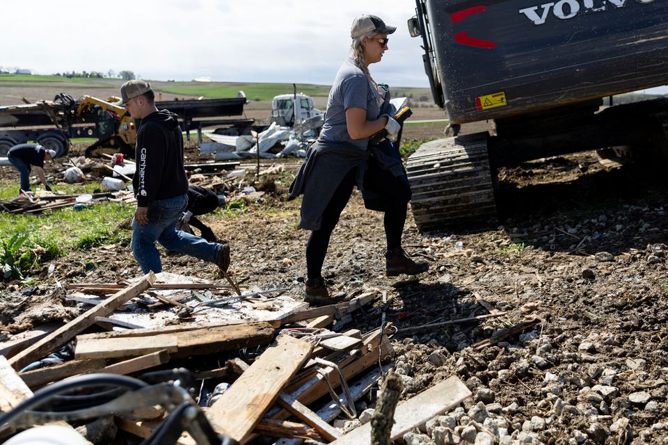 Tory Crozier, 30, cleans up the damage to her family's property near Minden, Iowa on Saturday, April 27, 2024, after a tornado the previous evening. (Anna Reed/Omaha World-Herald via AP)