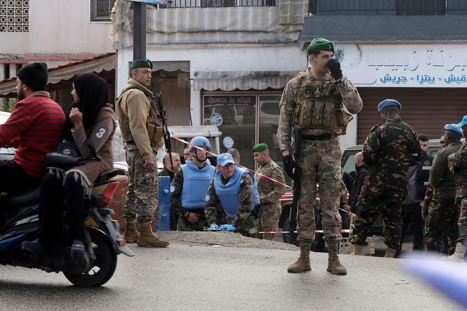 UN peacekeepers and Lebanese soldiers gather at the site where a UN peacekeeping force UNIFIL convoy came under small arms fire, in the village of Aqibya in south Lebanon, on December 15, 2022. - An Irish soldier of the UN peacekeeping force in south Lebanon near the Israeli border was killed and three wounded, Irish officials said. (Photo by Mahmoud ZAYYAT / AFP) (Photo by MAHMOUD ZAYYAT/AFP via Getty Images)