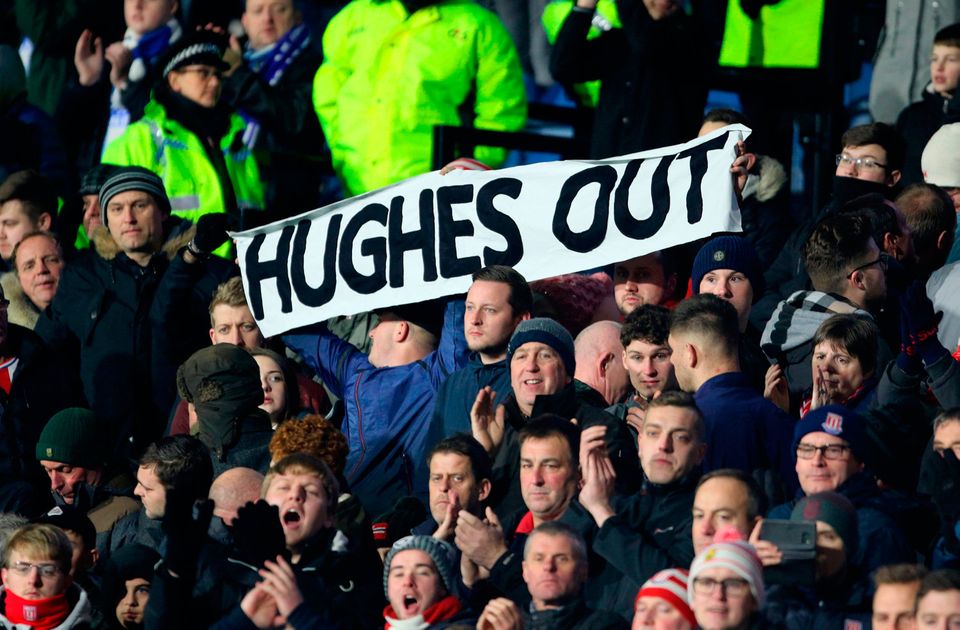 A Stoke City fan holds up a banner reading 'Hughes Out' at the John Smith's Stadium, Huddersfield. Photo: PA