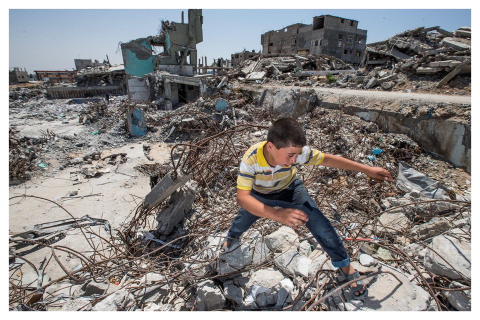Boy searching for metal at the site of a bombed out hospital in Gaza City. Photo: Mark Condren