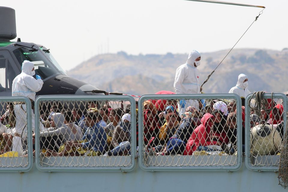 Migrants wait to disembark from the Italian Navy ship Bettica as it arrives at the Sicilian Porto Empedocle harbour (AP)