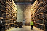 thumbnail: An employee passes American oak barrels containing Jameson whiskey, produced by Irish Distillers, in Middleton, a distillery believed to be operating at, or close to, capacity now