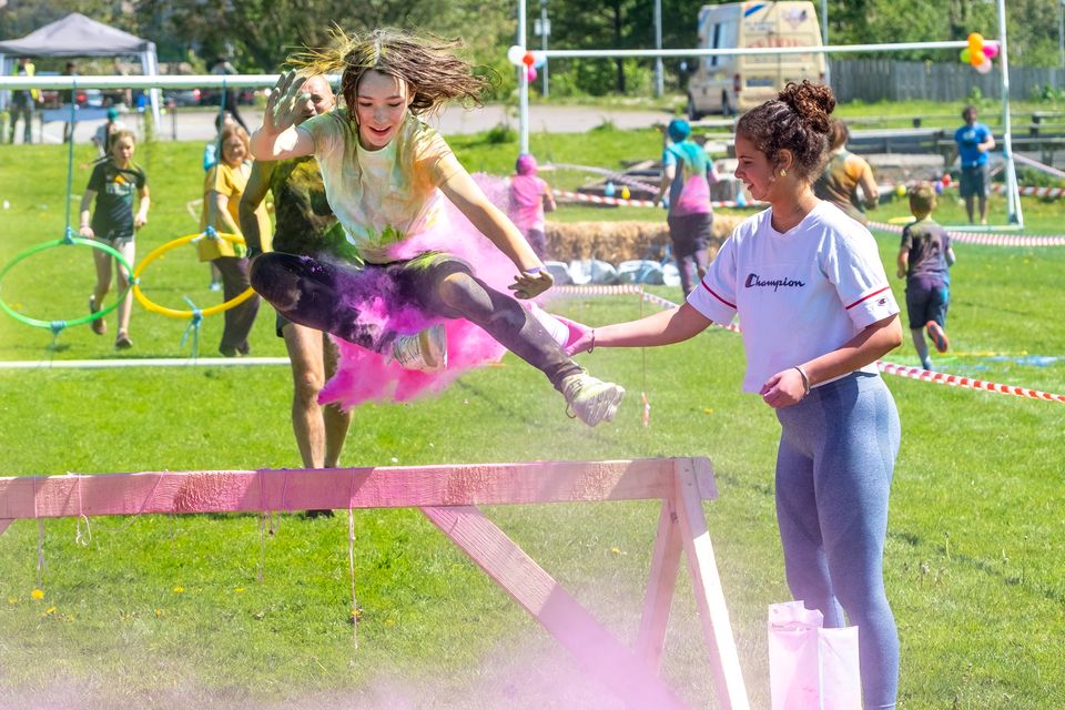 Holly Dixon jumps a hurdle as Lianna Bell adds some colour at the East Glendalough School Colour Run. Photo: Leigh Anderson