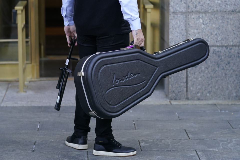 A member of Sheeran’s entourage carries a guitar case outside New York Federal Court (John Minchillo/AP)