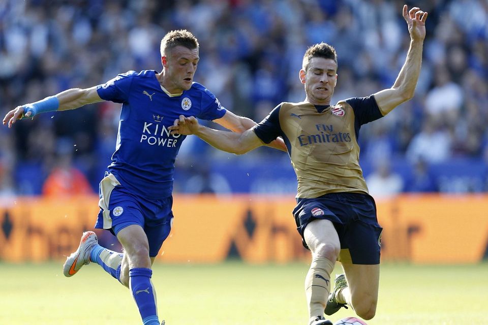 Leicester's Jamie Vardy, battling with Arsenal's Laurent Koscielny, has to wear a cast to protect his wrist