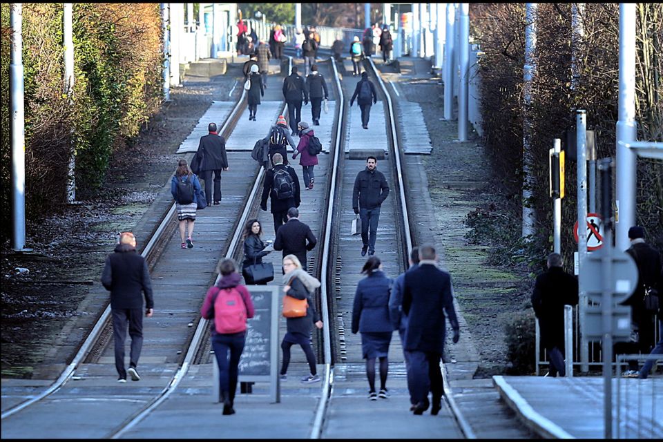 Commuters walk to town along the Luas tracks at Ranelagh during the Luas strikes in February. Photo: Steve Humphreys