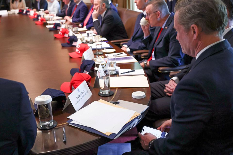 Mike Waltz checks the Signal app on his mobile phone while attending a cabinet meeting held by US president Donald Trump at the White House in Washington, on Wednesday. Photo: Reuters