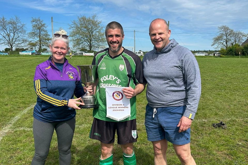 Bridget Nolan-Kenny of the Wexford Football League presenting the Division 4 trophy to Crossabeg AFC captain Mark Heffernan with manager Mick Halpin looking on.