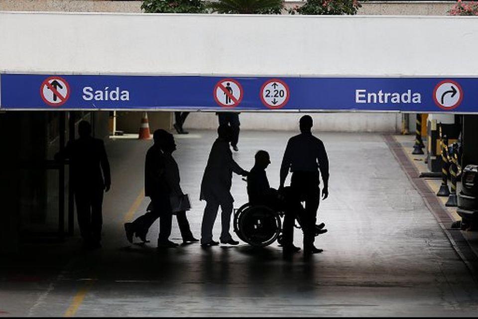 Pat Hickey, in wheelchair, is escorted by police to a waiting car at the Hospital Samaritano in Rio de Janeiro. Photo: Steve Humphreys