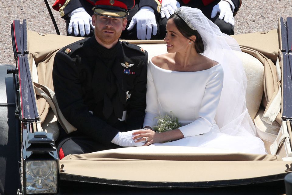 Britain's Prince Harry, Duke of Sussex and his wife Meghan,  Duchess of Sussex, are escorted by members of the Household Cavalry Mounted Regiment as they ride in the Ascot Landau Carriage and pass through the Cambridge Gate into the grounds of Windsor Castle at the end of their carriage procession in Windsor, on May 19, 2018 after their wedding ceremony. (Photo by Yui Mok / POOL / AFP)