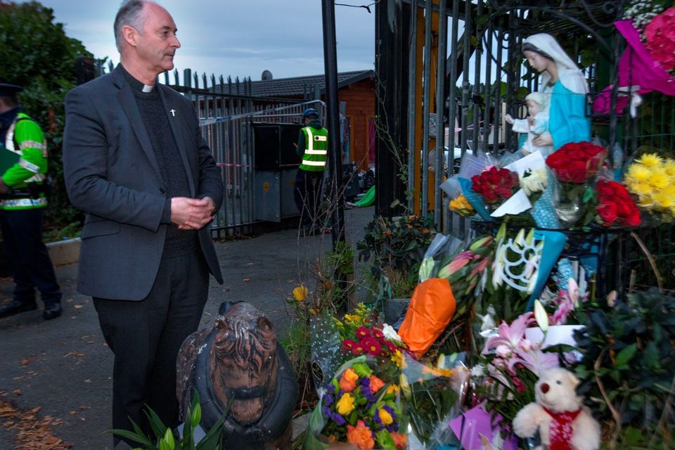 Fr. Derek Farrell, Parish Priest of the Parish of the Travelling Community looks at floral tributes at the scene of the tragic fire at Glenmaluck Road, Carrickmines yesterday. Photo: Tony Gavin. 
Photo: Tony Gavin 10/10/2015
