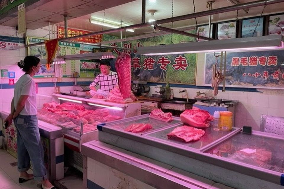 Shoppers at a butcher's counter in a wet market in Shanghai.