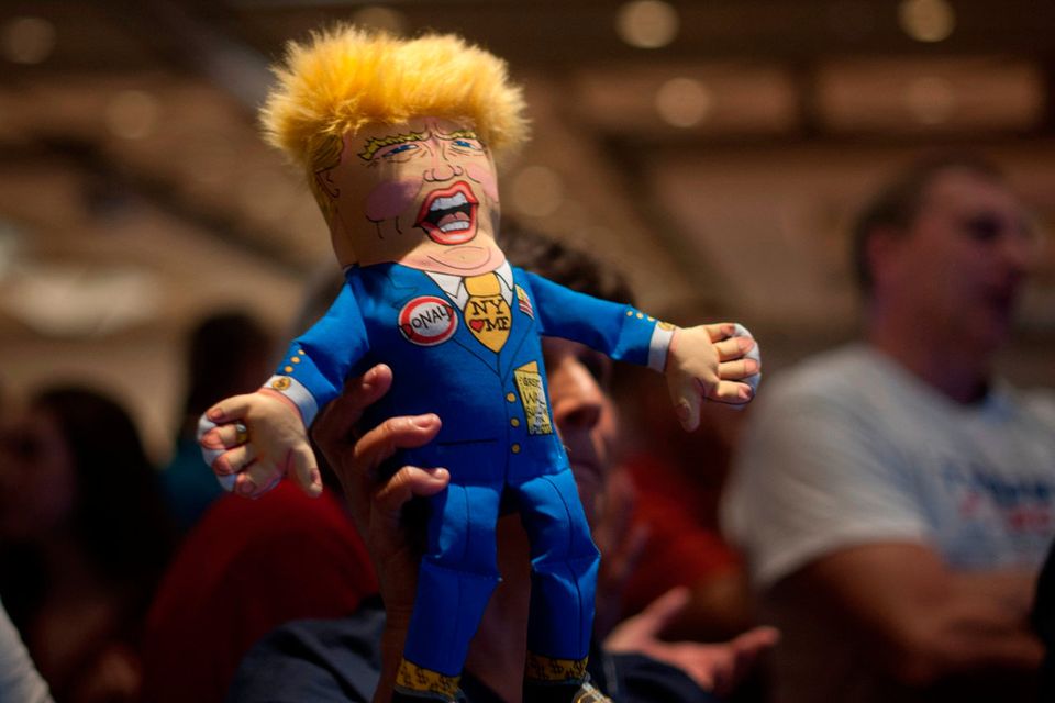 A supporter of Republican presidential candidate Donald Trump holds up a Trump doll during an election night party at a hotel in downtown Phoenix, Arizona on November 8, 2016. / AFP PHOTO / Laura SegallLAURA SEGALL/AFP/Getty Images