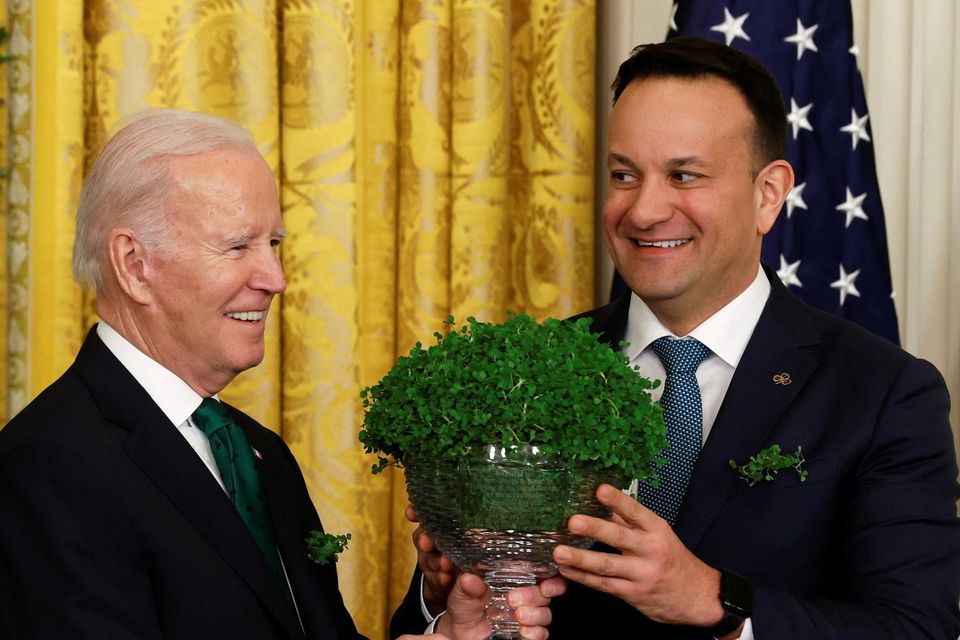 Taoiseach Leo Varadkar (right) presents US president Joe Biden with the traditional gift of a bowl of shamrock in the East Room of the White House in Washington on St Patrick's Day. Photo: Reuters