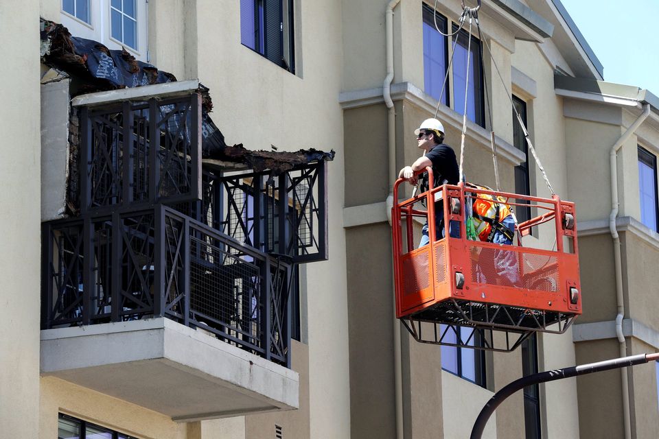 Workmen examine the damage at the scene of the balcony collapse in Berkeley, California