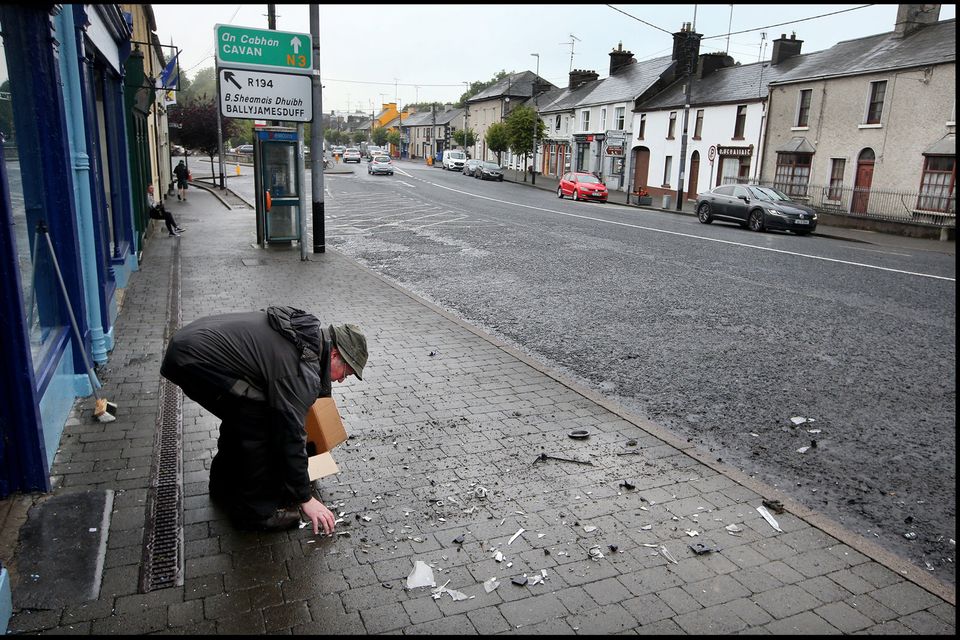 Ray Arnold cleans up the damage across the road from the scene of the ATM foiled raid on the Main Street in Virginia, Co Cavan.
Pic Steve Humphreys