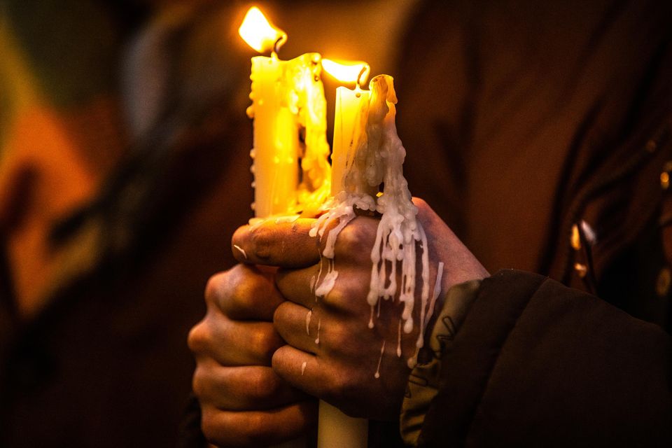 A woman holds a candle at a vigil in memory of Ashling Murphy outside Leinster House. Photo: Mark Condren