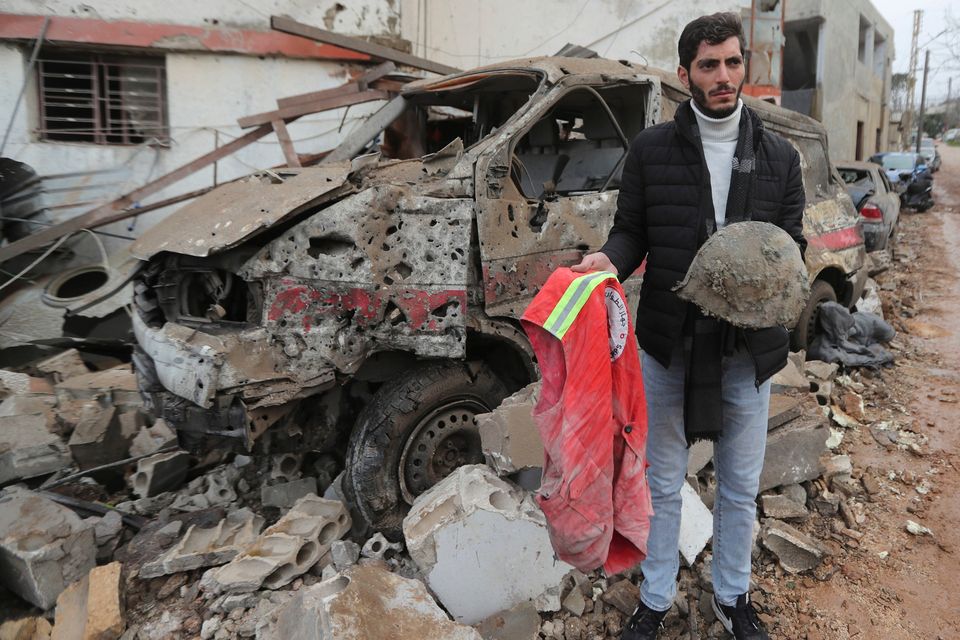 A man carries belongings of a paramedic killed at a paramedic center the was hit by an Israeli airstrike early Wednesday in Hebbariye village, south Lebanon, Wednesday, March 27, 2024. (AP Photo/Mohammed Zaatari)