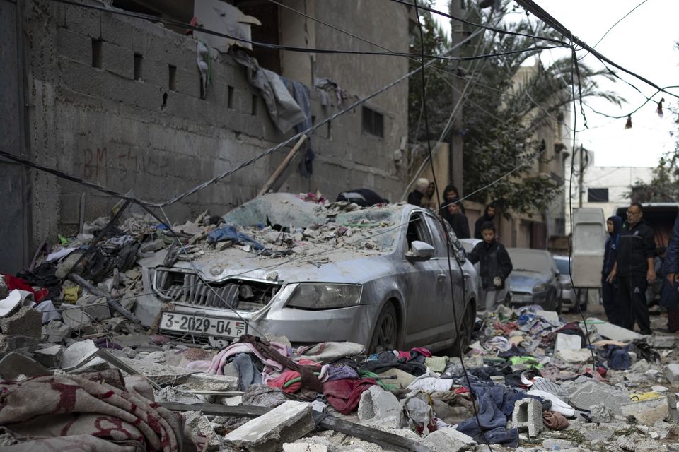 Palestinians look at the destruction after an Israeli airstrike in Rafah (Fatima Shbair/AP)