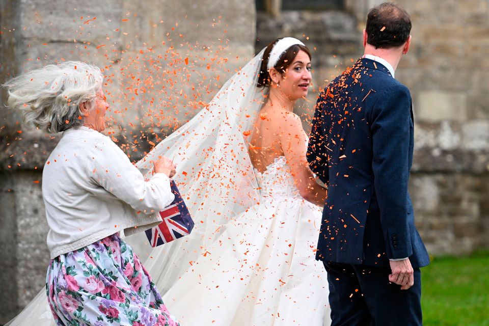 A woman throws confetti as former UK Chancellor George Osborne and Thea Rogers leave after their wedding at St Mary's Church in Bruton, England. Photo: Finnbarr Webster/Getty Images