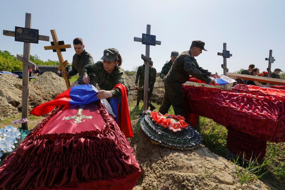 Military personnel take part in a funeral ceremony to bury the remains of 60 service members of the Russian armed forces and three civilians at a cemetery in Luhansk, Russian-controlled Ukraine. Photo: Reuters