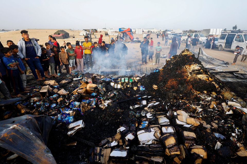 Palestinians look at the damage as they search for food among burned rubble at the site of an Israeli attack on an area intended for displaced persons, in Rafah in the southern Gaza Strip, May 27, 2024. REUTERS/Mohammed Salem