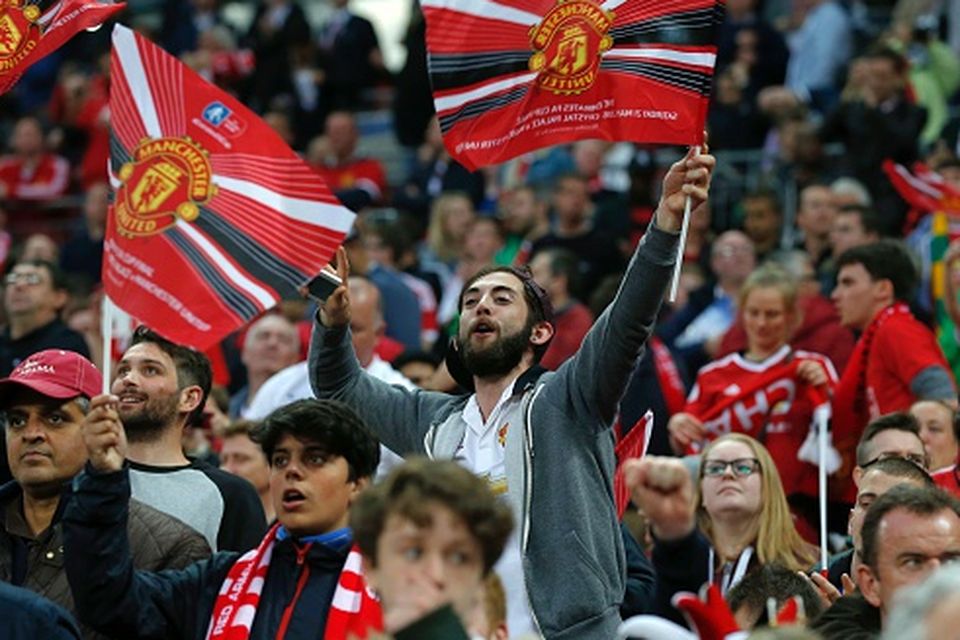 Manchester United fans celebrate their team's victory during the English FA Cup final football match between Crystal Palace and Manchester United at Wembley stadium in London on May 21, 2016. / AFP / Ian Kington / NOT FOR MARKETING OR ADVERTISING USE / RESTRICTED TO EDITORIAL USE        (Photo credit should read IAN KINGTON/AFP/Getty Images)