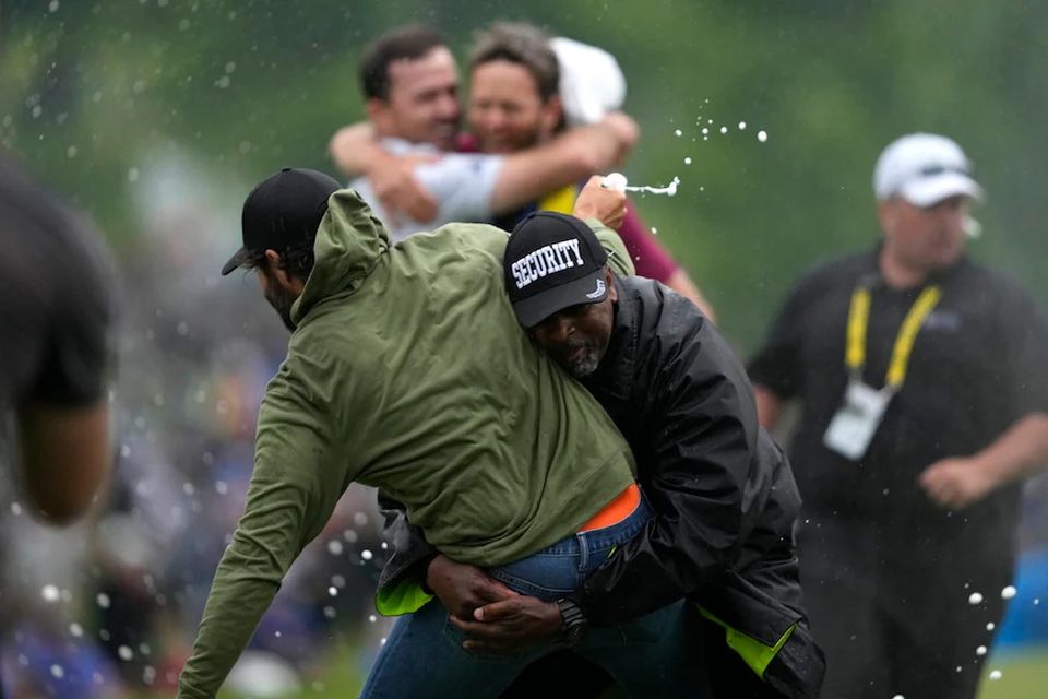 Canadian golfer Adam Hadwin ran on the 18th green spraying champagne before a security guard tackled him