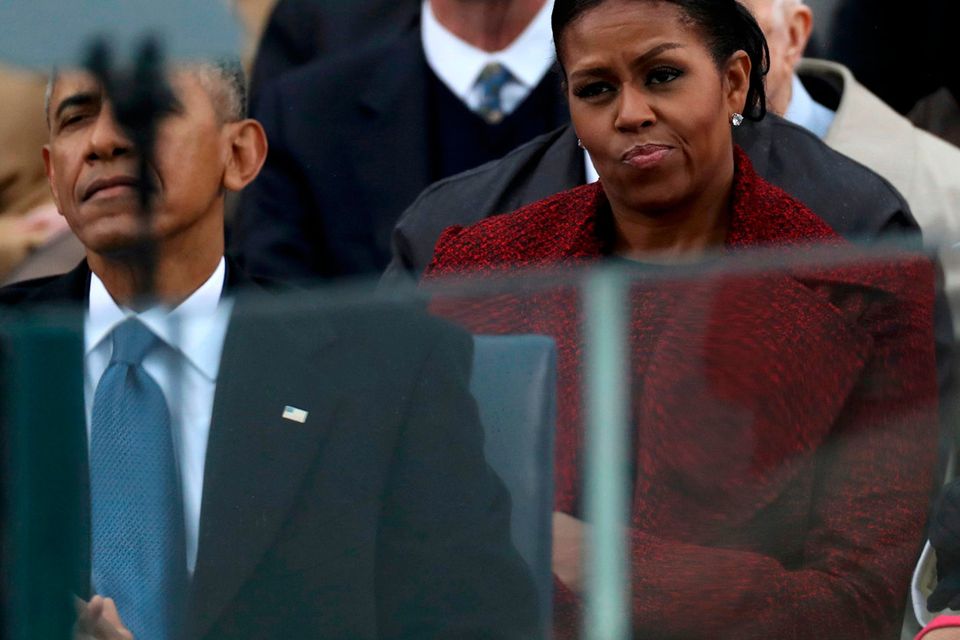 Outgoing U.S. first lady Michelle Obama listens with outgoing President Barack Obama (L) to incoming President Donald Trump speak during inauguration ceremonies at the U.S. Capitol in Washington, U.S., January 20, 2017. REUTERS/Carlos Barria