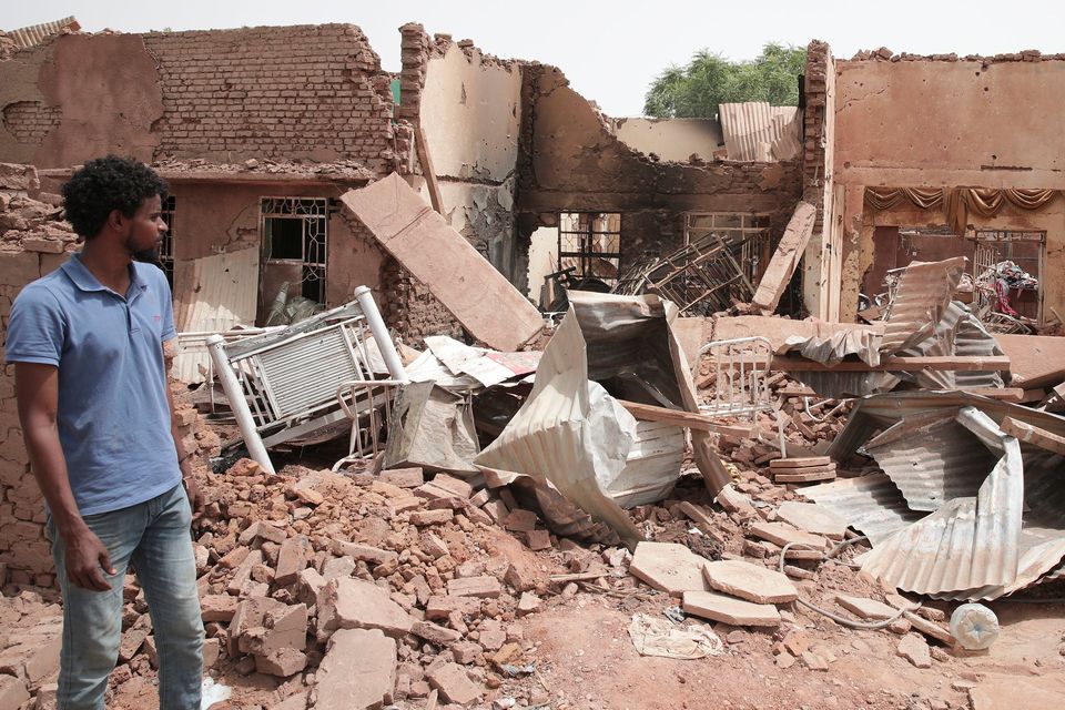 A man walks by a house hit in recent fighting in Khartoum. Photo: Marwan Ali