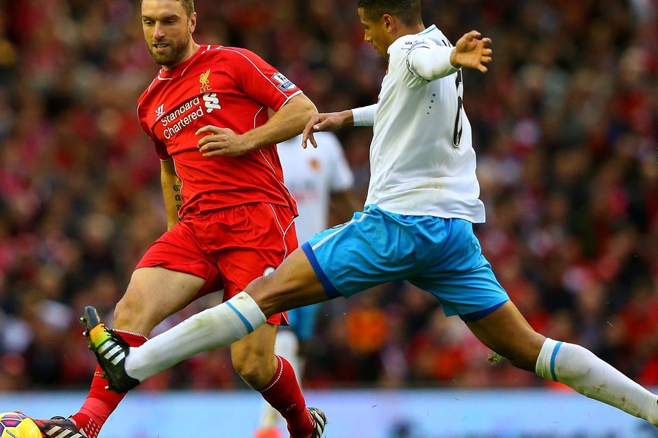 Rickie Lambert passes the ball under pressure from Curtis Davies. Alex Livesey/Getty Images