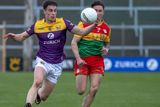 thumbnail: Wexford centre-back Páraic Hughes on the move away from Carlow’s Shane Clarke.
