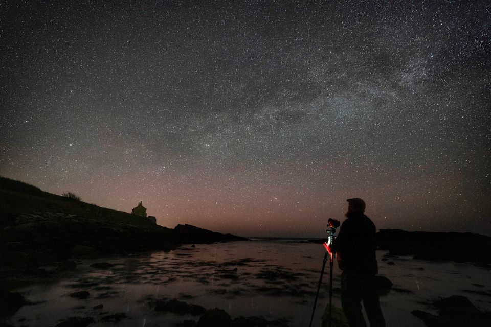 An astronomer on the Northumberland coastline, England, looks up at the Milky Way. Photo: PA