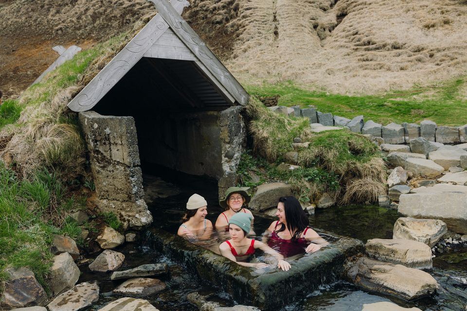 Friends enjoy a dip in a natural thermal spa. Photo: Getty