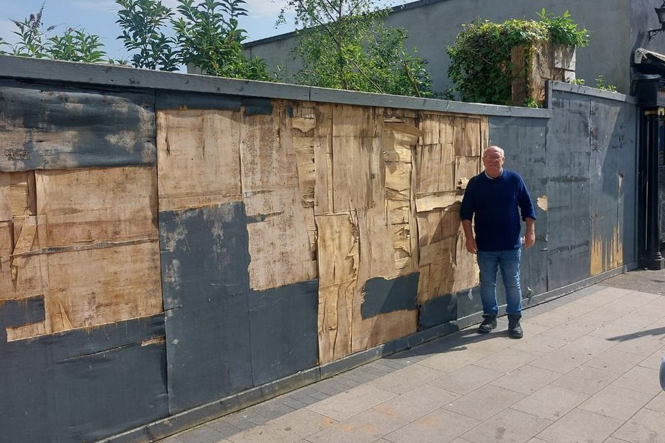 Cllr Jackser Owens at the hoarding which is a cause of concern.