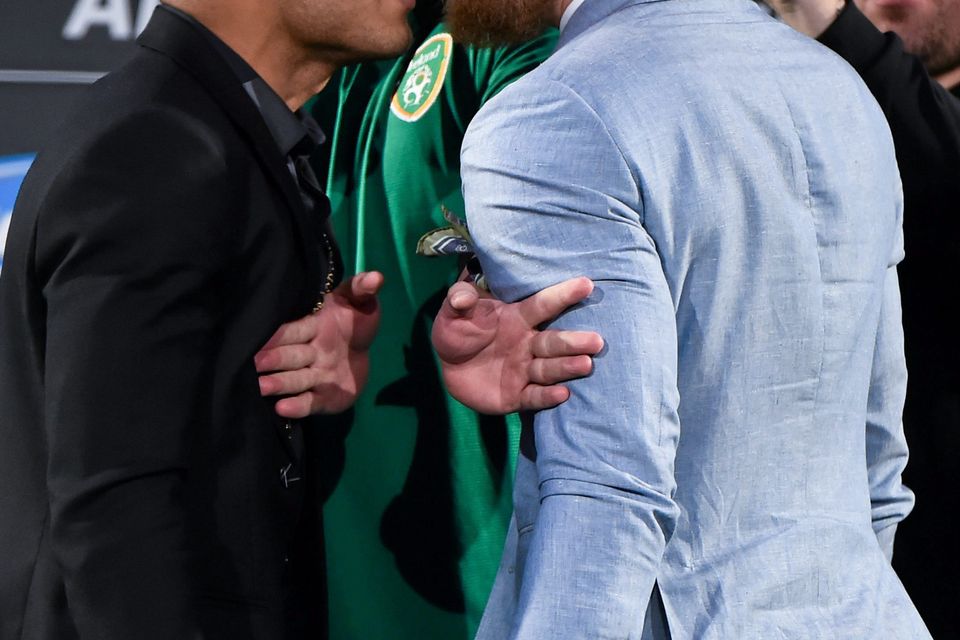 UFC featherweight Champion Jose Aldo, left, faces off against UFC featherweight title challenger Conor McGregor as UFC President Dana White tries to separate them during a UFC fan event.