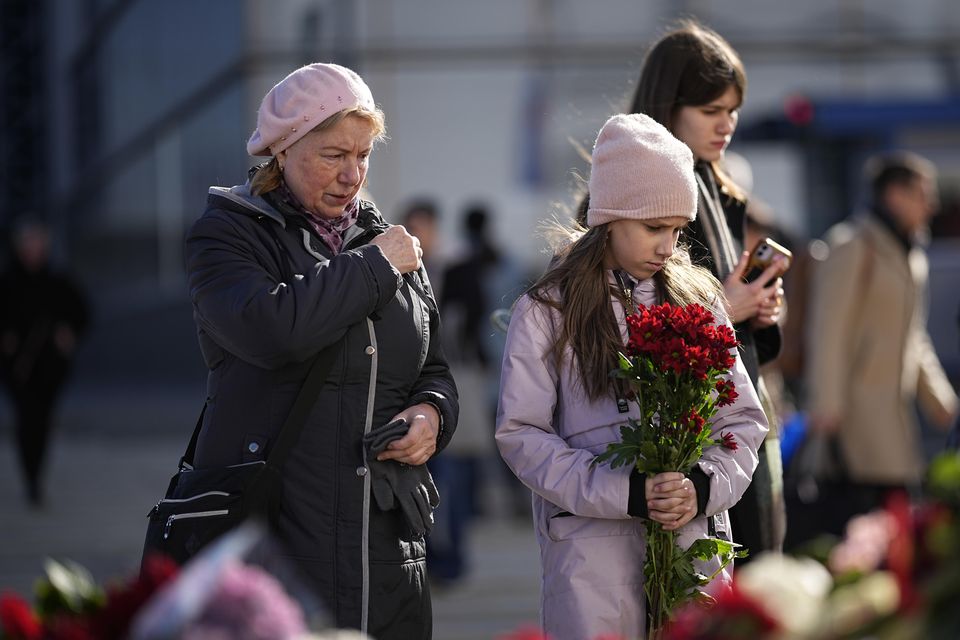 People stand at a makeshift memorial in front of the Crocus City Hall on the western outskirts of Moscow (AP)