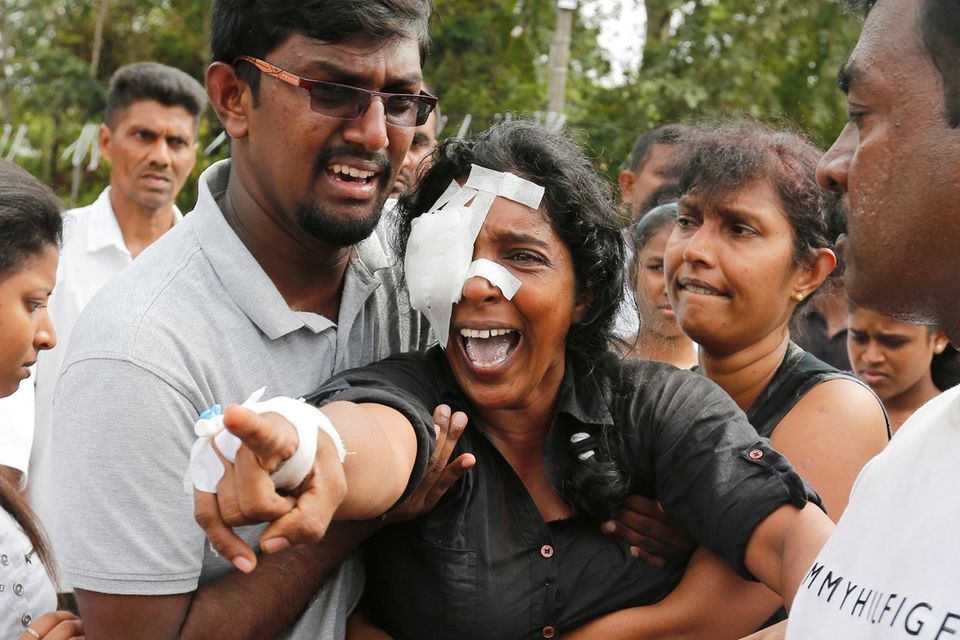 Devastation: Kumari Fernando, who lost her husband and two children in the bombings, at a mass burial yesterday. Photo: Thomas Peter/Reuters