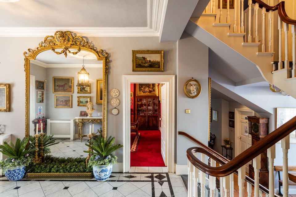 The entrance hall with marble floor tiles and giant mirror at Springfield House